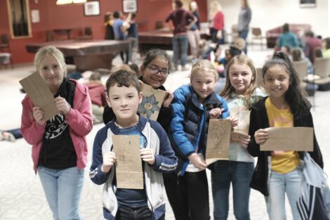 A group of fourth graders pose with their decorated bags