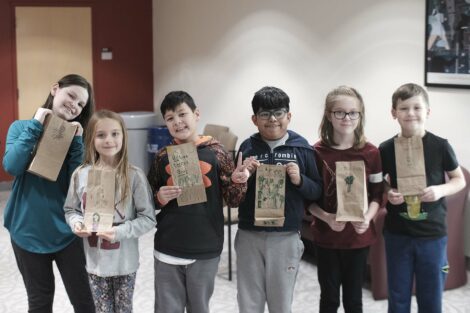 A group of fourth graders pose with their decorated bags