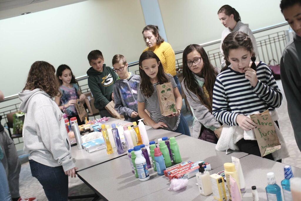 Fourth graders select items for their donation bags
