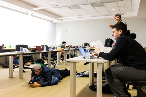 Members of the baseball team either study or watch a Barstool Sports video.