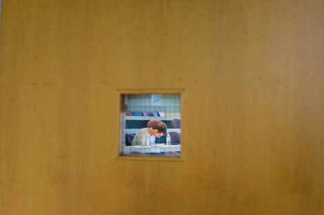 a student takes a final seen through a door
