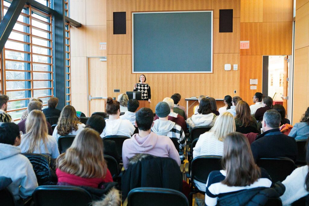 Kate Racculia guest reader and Flash Fiction contest judge stands at podium