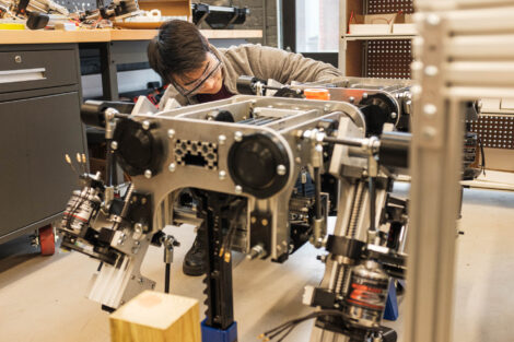 Sanha Lee '20 inspects the quadrupedal robot he is helping to engineer.