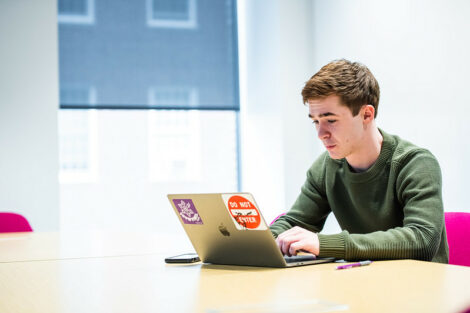 A student works with a laptop on the first day of spring semester.