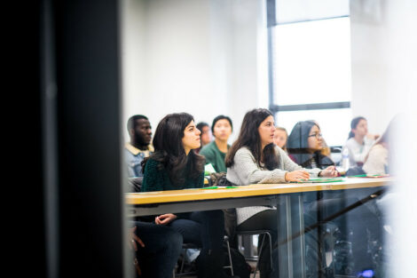 Students listen to their professor in a classroom on the first day of spring semester.