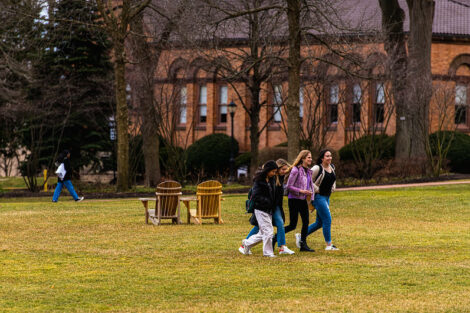 Four students walk together on the Quad near Van Wickle Hall on the first day of spring semester.
