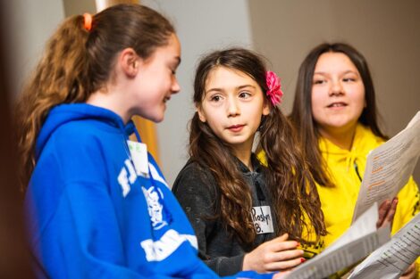 Three middle school students talk.