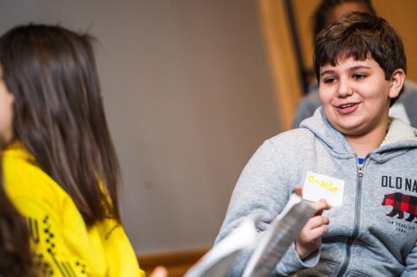 A middle school student talks to another student.