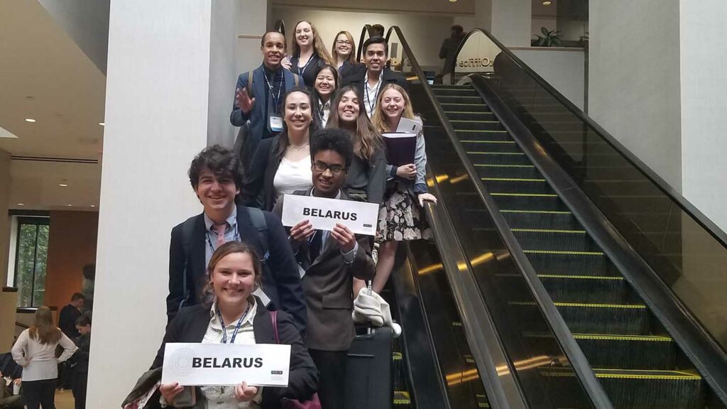 Model UN students hold signs representing their country Belarus