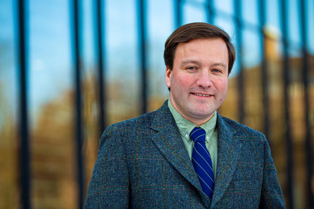 Thomas Lannon smiles as he poses outside the library