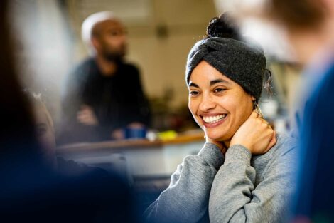 Artist Chloe Bass smiles as she works with students