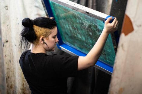 A student works on washing a screen