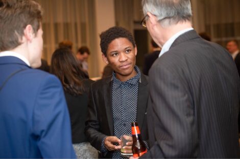 Student listens attentively as he networks with alum