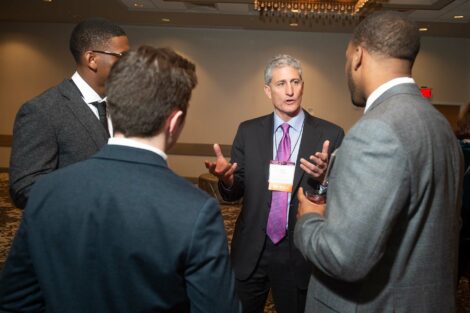 Alum JB Reilly talks to a group of young men at Networking Night