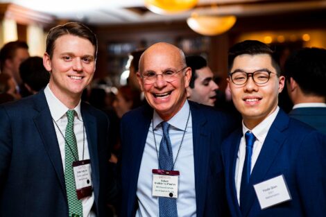 Alum and students smile at camera