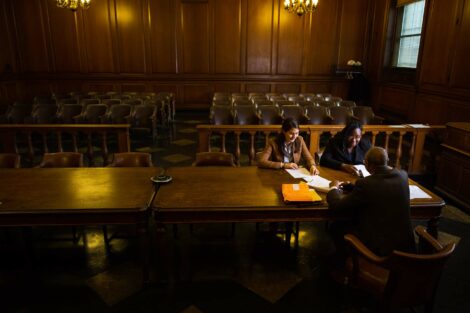 Students participating in externship sit with judge in a New York State courtroom