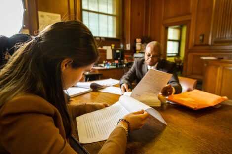 Student extern looks over paperwork with judge in background