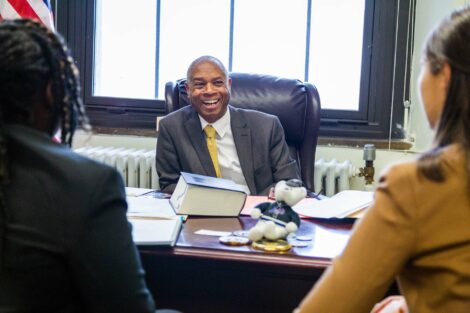 Judge smiles as he speaks with student externs in his chamber