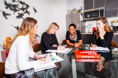 Alumni team at Novita sit around desk with extern.