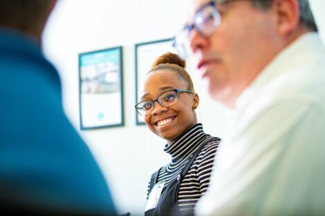 Extern smiles as she sits in meeting at Olympus