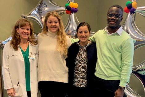 Student externs pose with host