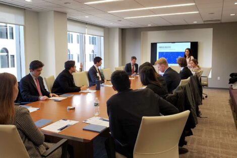 Students sit around conference table