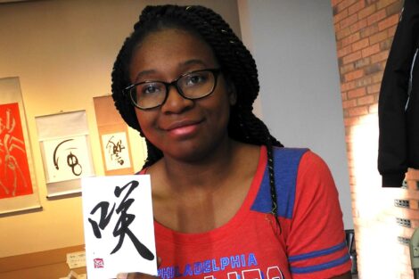 Student holds work created for her