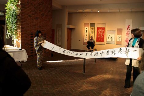 calligraphy master Shuho Kondo holds up scroll