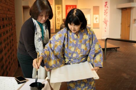 calligraphy master Shuho Kondo dips her brush in the ink