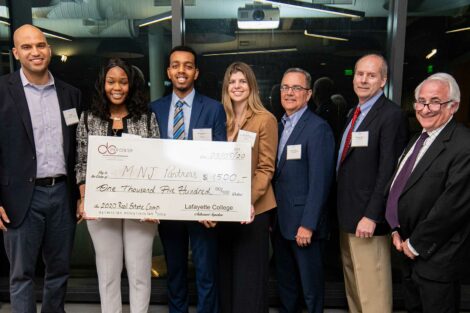 Winning team holds check with judges