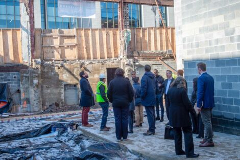 Students and local alum stand inside new construction in Easton