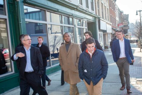 Students walk with track leader down the streets of Easton