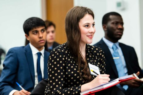 A student takes notes during a talk