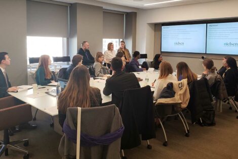 Student sit around a conference table