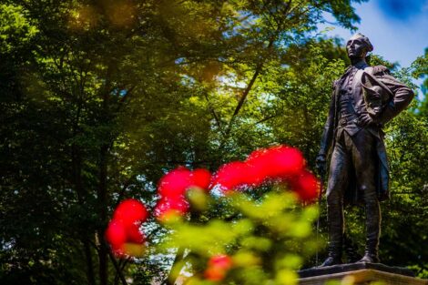 the Marquis statue with red flowers