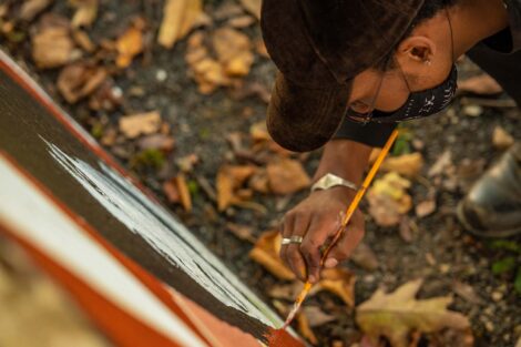 Habib Fall adds paint to the wall