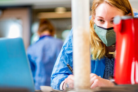 a student in a mask in a biology lab in Rockwell measures popcorn