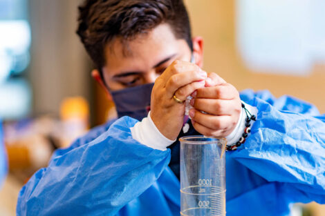 a student in a mask in a biology lab in Rockwell measures popcorn