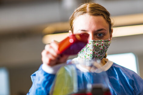 a student in a mask in a biology lab in Rockwell measures popcorn