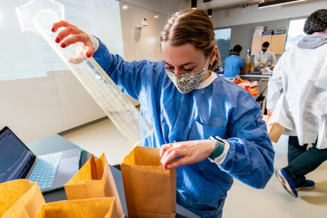 a student in a mask in a biology lab in Rockwell measures popcorn