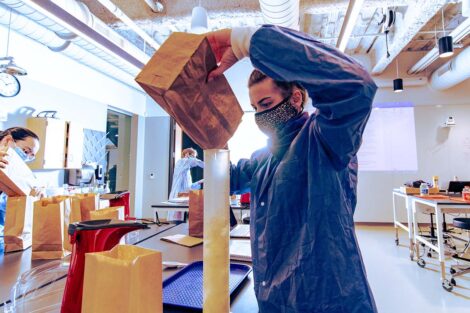 a student in a mask in a biology lab in Rockwell measures popcorn