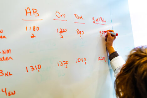 Prof. Nancy Waters writes data on a white board
