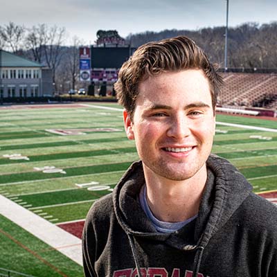 Student smiles as he is perched above the field at Kirby Stadium