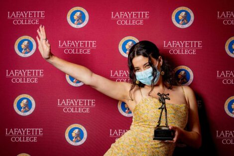 Alexandra Kirtchuk '21 holding Aaron O. Hoff Award statue and standing in front of Lafayette College backdrop