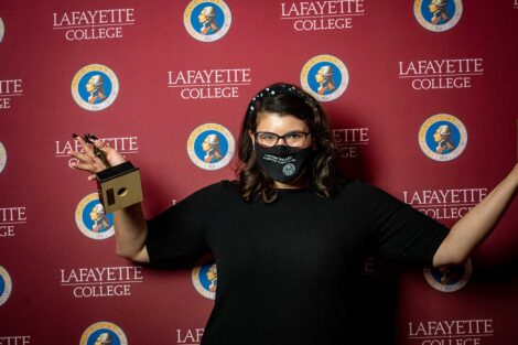 Angela Bell holding Aaron O. Hoff Award and standing in front of Lafayette College backdrop