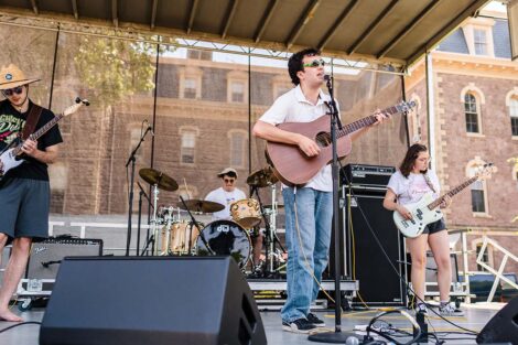 students play in a band on a stage on the Quad