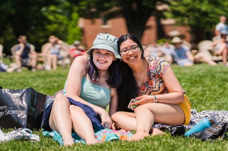 students sit on the Quad and listen to the bands