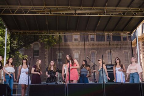 a group of singers perform on stage on the Quad