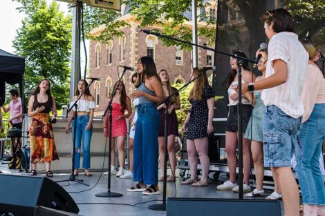 a group of singers perform on stage on the Quad