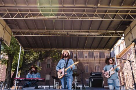 students play in a band on a stage on the Quad